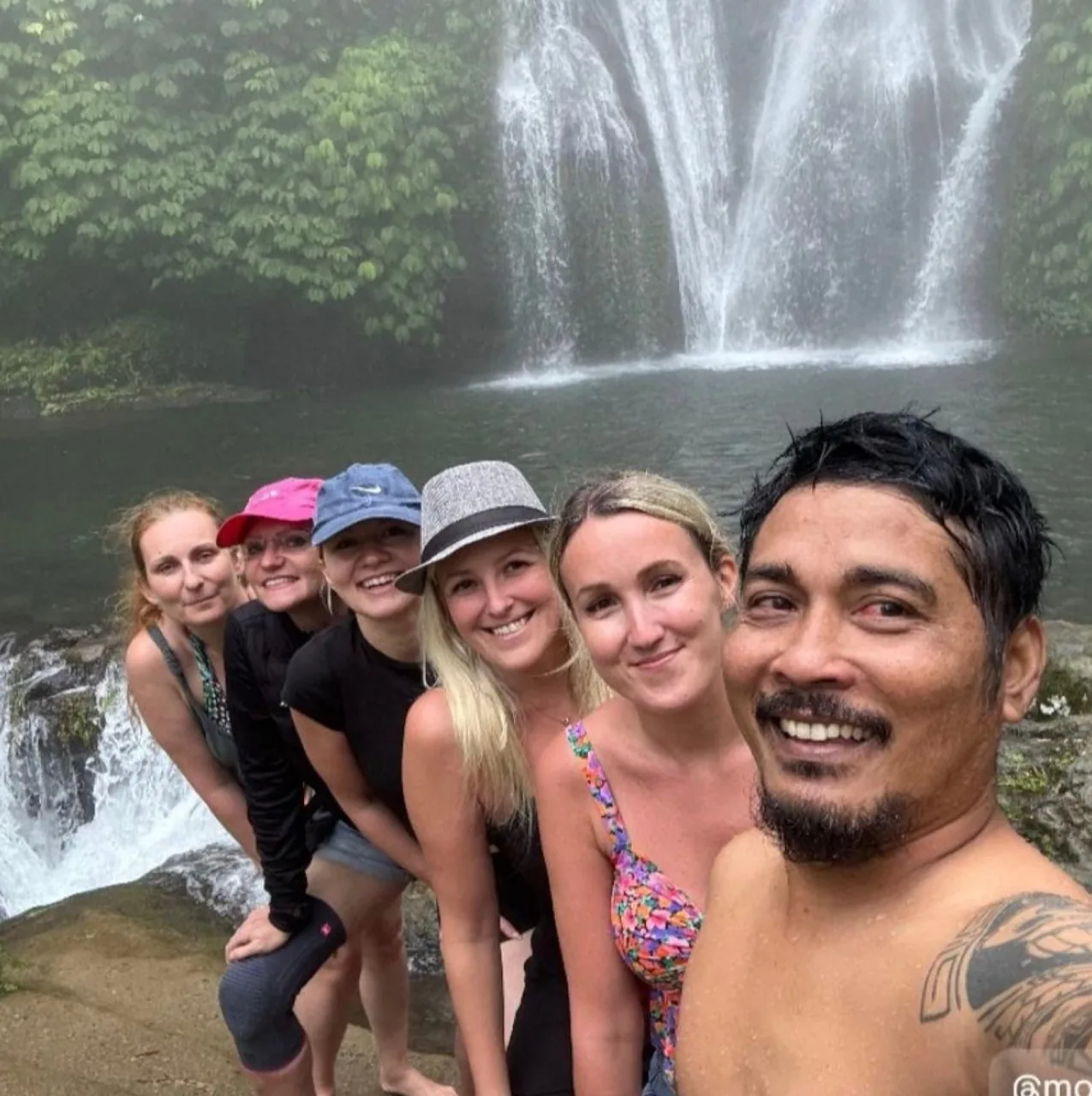 Travelers at a jungle waterfall in north Bali